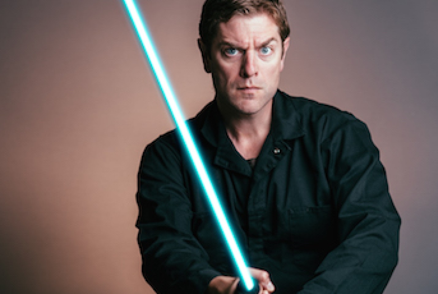 Artist Charles Ross holding blue lightsaber.